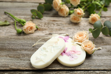 Scented sachets and flowers on wooden table