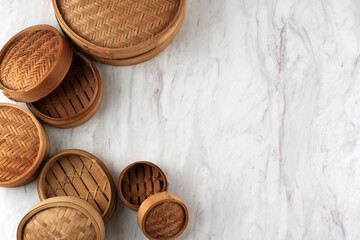 Various Size of Traditional Asian Kitchen Utensil Bamboo Steamer Set Over White Wooden Background. Top View, Flat Lay. Copy space for Text.
