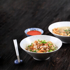 Mie Yamin or Yamin Noodle with Chopped Chicken Meat and Vegetable. Taste Sweet from Soy Sauce. Served on Ceramic Bowl with Sambal