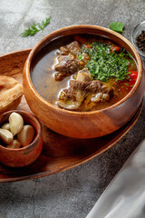 Beef goulage with garlic and pita bread on a gray stone table, Flatlay