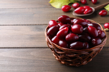 Fresh ripe dogwood berries in wicker bowl on wooden table. Space for text
