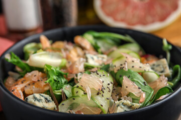 Delicious pomelo salad with shrimps, cheese and chia seeds in bowl, closeup