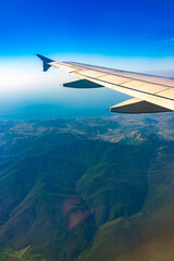 Fototapeta premium View from the airplane window at a beautiful blue clear sky and the airplane wing