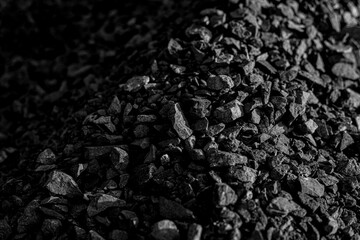 Coal. Combustible sedimentary rocks are brown to black in color. Caused by the accumulation of natural plant remains.