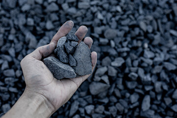 Coal mining : coal miner in the man hands of coal background. Picture idea about coal mining or energy source. Industrial coals. Volcanic rock.