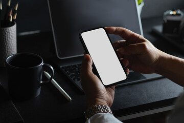 a businessman using smartphone at his office desk.