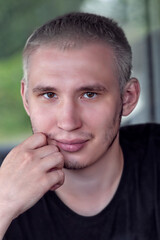 Portrait of a serious guy with gray hair wearing a black T-shirt