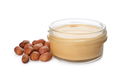 Jar with delicious peanut butter and nuts on white background
