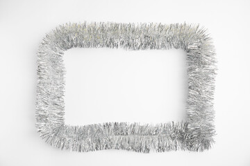 Frame of silver tinsel on white background, top view. Space for text