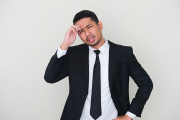 Adult Asian man wearing black suit and tie showing sad expression