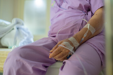 Fototapeta premium giving saline to the hand of an old woman, medical treatment