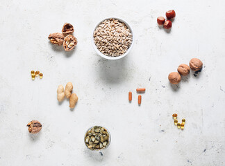 Different seeds and nuts with pills on grunge background