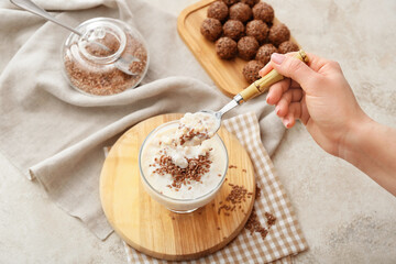 Eating of tasty dessert with flax seeds and yoghurt from glass