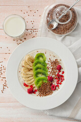 Tasty yoghurt with fruits and flax seeds in bowl on table