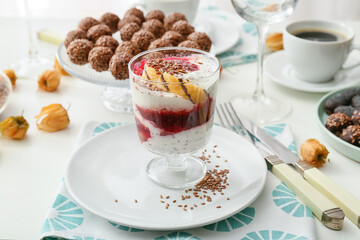 Tasty dessert with flax seeds and yoghurt in glass on table