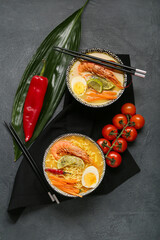 Bowls of tasty Thai soup on dark background