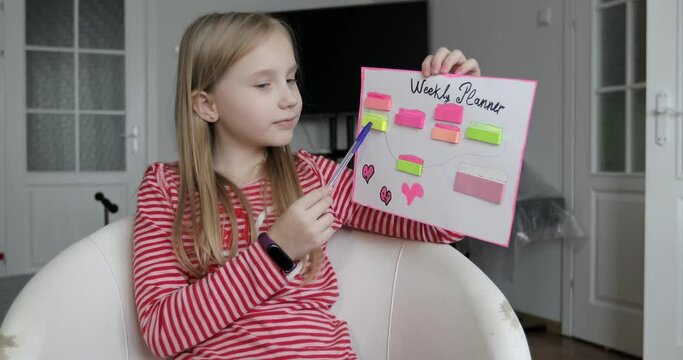 Teenage girl shows her weekly planner. The schoolgirl tells.