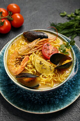 Bowl of tasty Thai soup on dark background