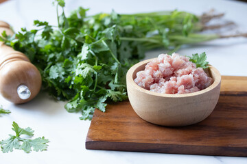 Ground raw pork in a wooden cup