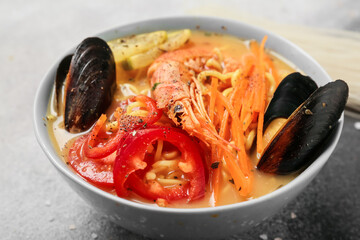 Bowl of tasty Thai soup on grunge background