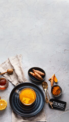Healthy turmeric golden tea on light gray background.