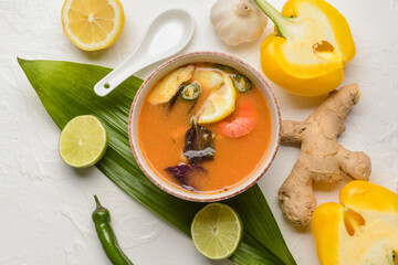 Bowl of spicy Thai soup on white background
