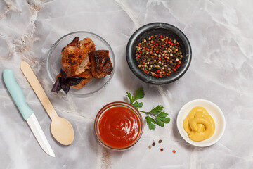 Grilled pork in a bowl with sauces and spices.