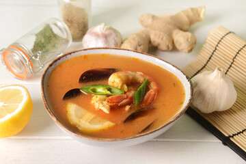 Bowl of spicy Thai soup on table