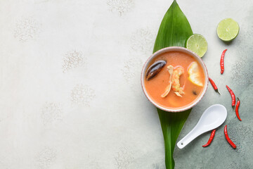 Bowl of spicy Thai soup on grunge background