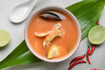 Bowl of spicy Thai soup on grunge background