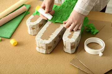 Woman making traditional Mexican pinata at table