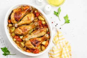 Ginger orange roast chicken legs with vegetables in baking dish. Top view, copy space.