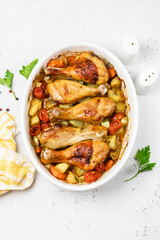 Lemon garlic roast chicken legs with vegetables in baking dish. Top view, copy space.