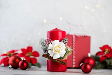  Christmas red candle surrounded by Christmas balls on a light background. Copy space.