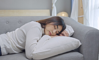 Obraz premium Exhausted or bored young sleepy woman falls down on sofa at home alone.