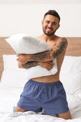 Handsome young man in underwear on bed