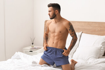 Sexy young man in underwear on bed