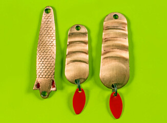 A set of fishing spinners on a green background.