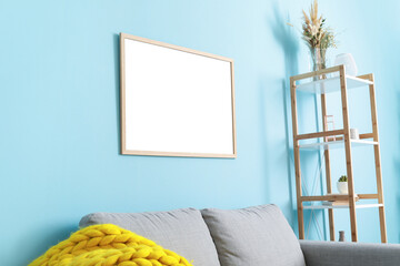 Blank poster hanging on color wall in interior of stylish living room