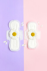 Flowers and menstrual pads on color background