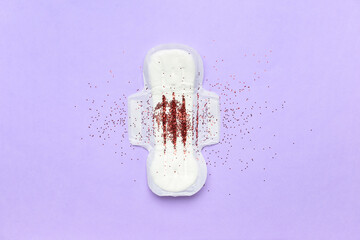 Confetti and menstrual pad on purple background