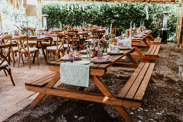 Terrace with tables setup with flowers and plates on table decorated for Wedding Reception in Latin America