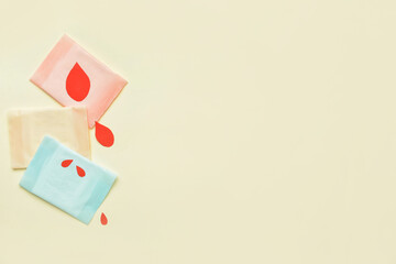 Menstrual pads and paper blood drops on light background
