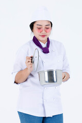 Portrait studio shot of Asian professional restaurant cooking female executive chef in cook uniform and scarf standing smiling look at camera holding stainless pot and cover on white background