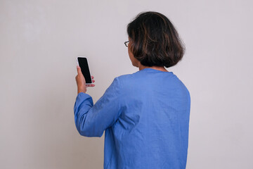 person facing backward, using phone to make video call