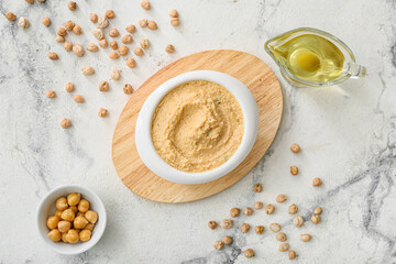 Composition with delicious hummus and oil on light background
