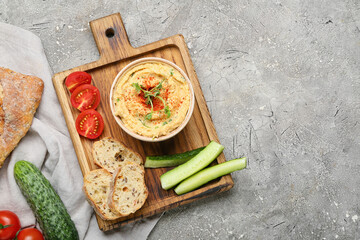 Composition with delicious hummus, bread and vegetables on grey background