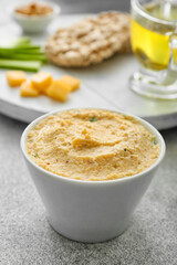 Bowl with delicious hummus on table, closeup