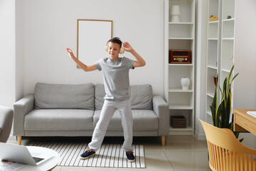 Funny little boy with laptop learning to dance at home © Pixel-Shot