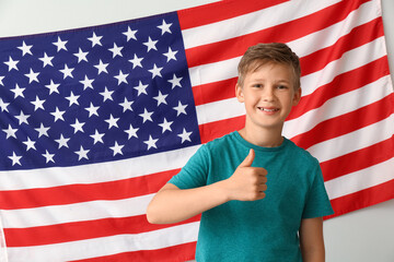 Pupil of language school showing thumb-up near light wall with USA flag